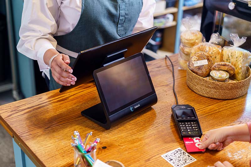Store owner accepting payment with credit card chip reader.